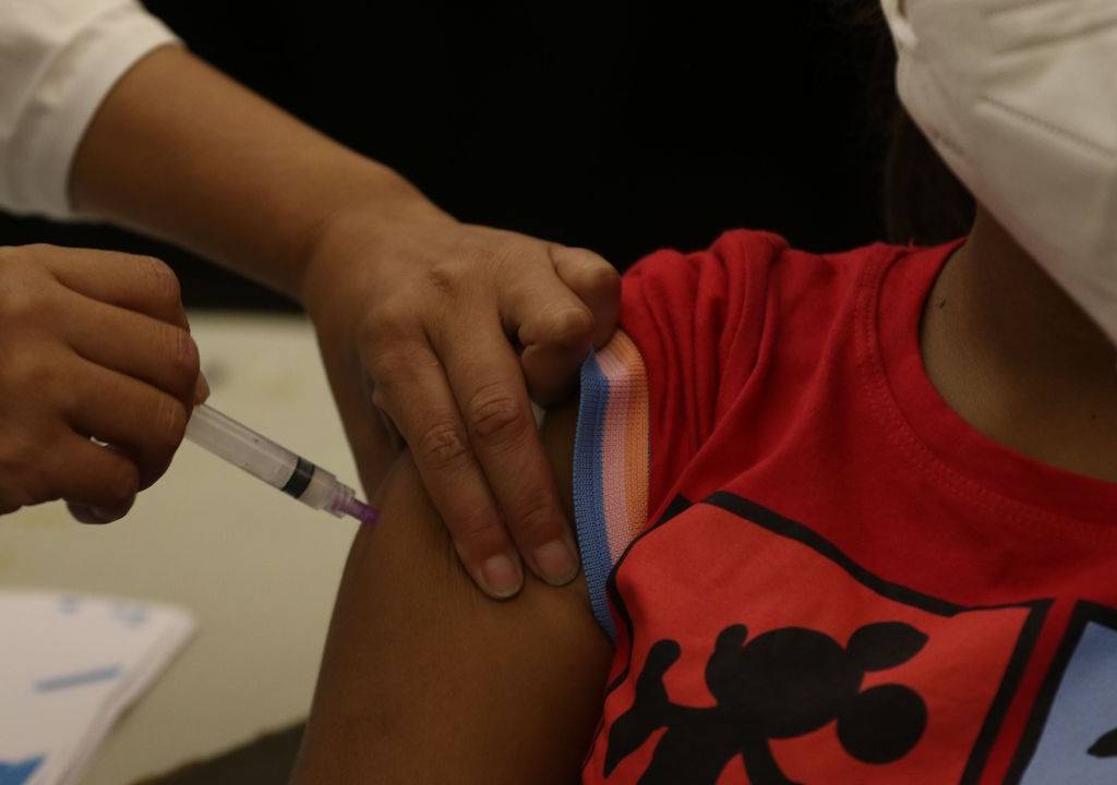 Foto mostra criança sendo vacinada contra a Covid-19