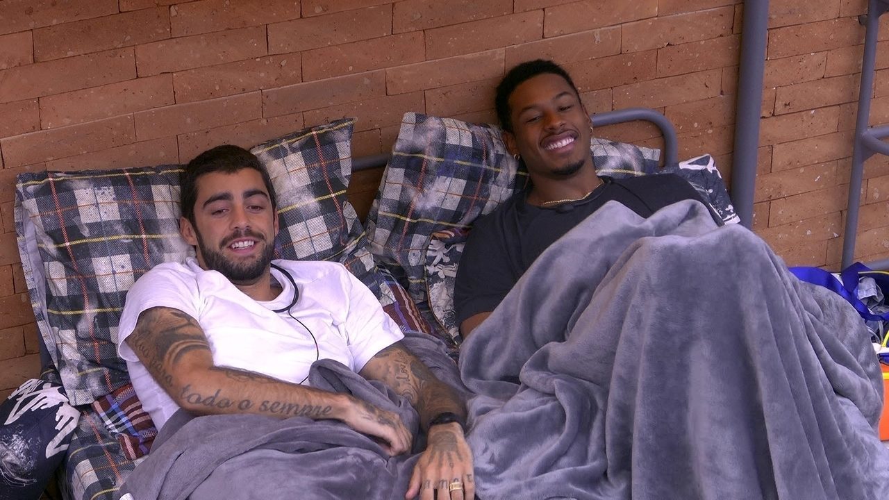 Foto mostra Pedro Scooby e Paulo André juntos deitados em uma cama