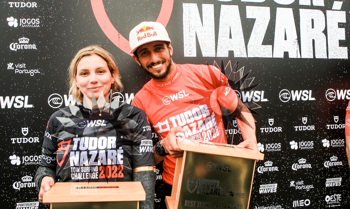 Os surfistas Maya Gabeira, de blusa preta, e Lucas Chumbo, de blusa vermelha e boné branco, seguram seus troféus