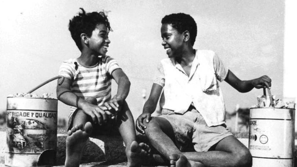 Foto mostra dois meninos rindo em foto preto e branco