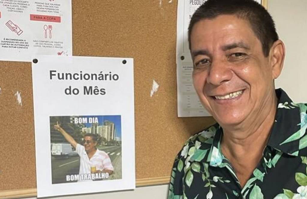 Foto mostra Zeca Pagodinho ao lado de placa de funcionário do mês