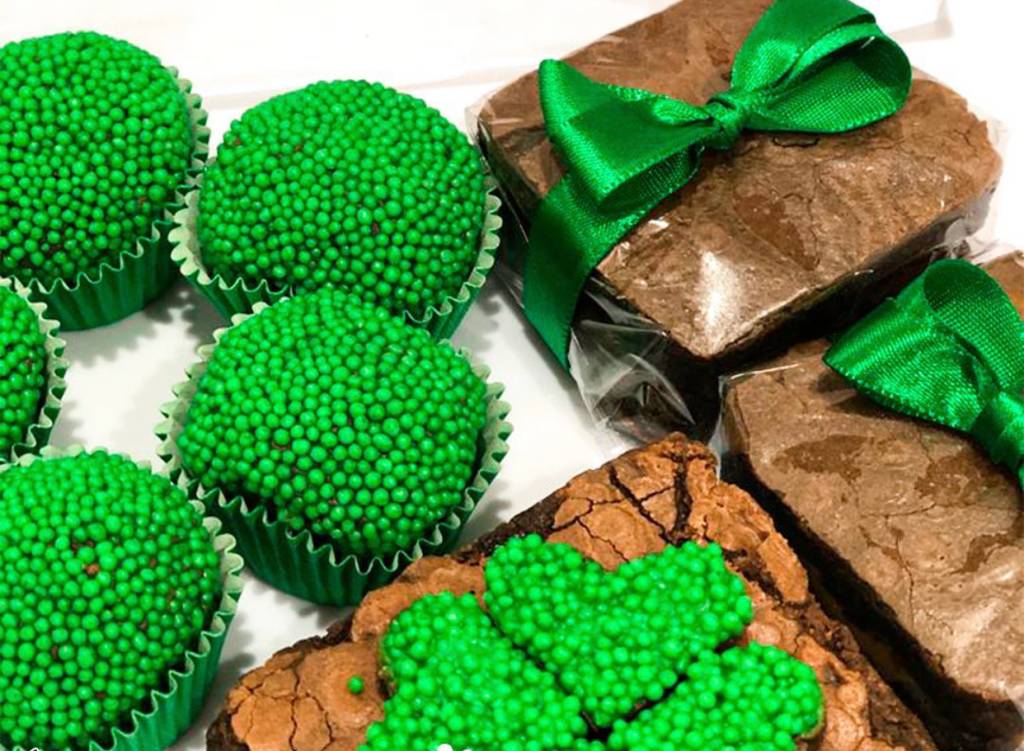 Foto mostra brigadeiros verdes e brownies embalados