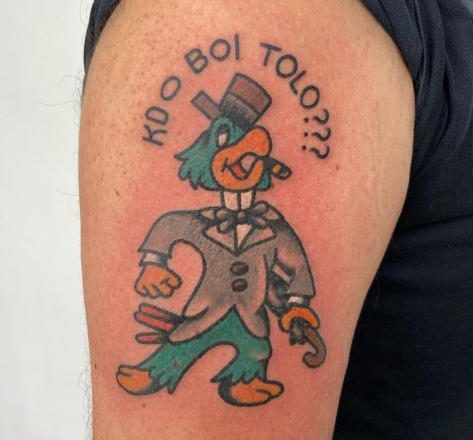 Tatuagem com o personagem Zé Carioca e a frase: 