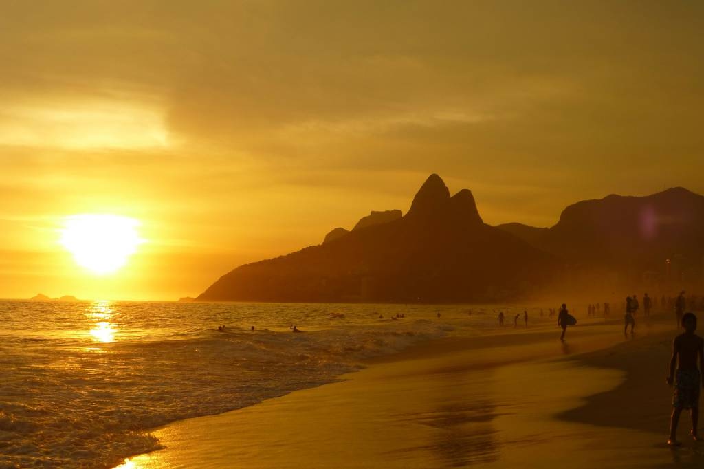Foto mostra pôr do sol no Rio de Janeiro na praia de Ipanema com a vista do morro Dois Irmãos