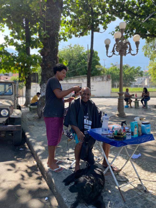 Um corte de cabelo no Largo do Piolho sob o lampadário histórico