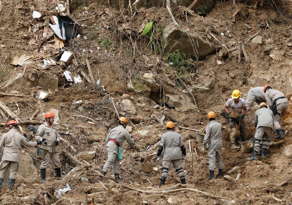 Foto mostra equipe de bombeiros resgatando corpos após tragédia em Petrópolis