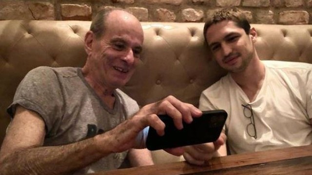 ney matogrosso Ney Matogrosso e Gabriel Leone sentados em um sofá marrom com encosto em capitoné