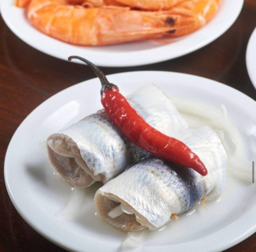 Foto mostra rolinhos de sardinha com uma pimenta em cima