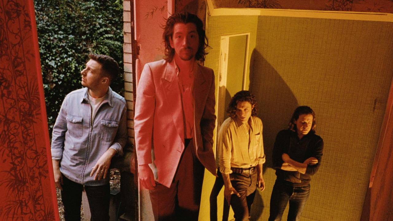 Os quatro integrantes do grupo Arctic Monkeys de pé, encostados em paredes, com o vocalista Alex Turner, o segundo da esquerda pra direita, à frente