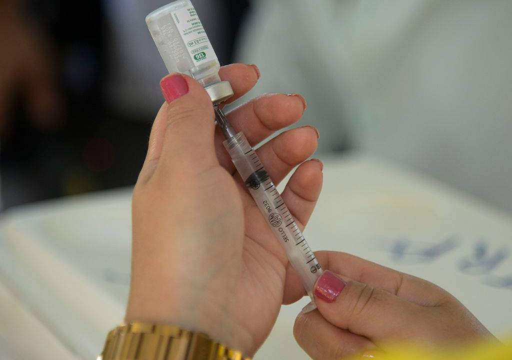 Foto mostra pessoa aplicando vacina contra a Covid-19