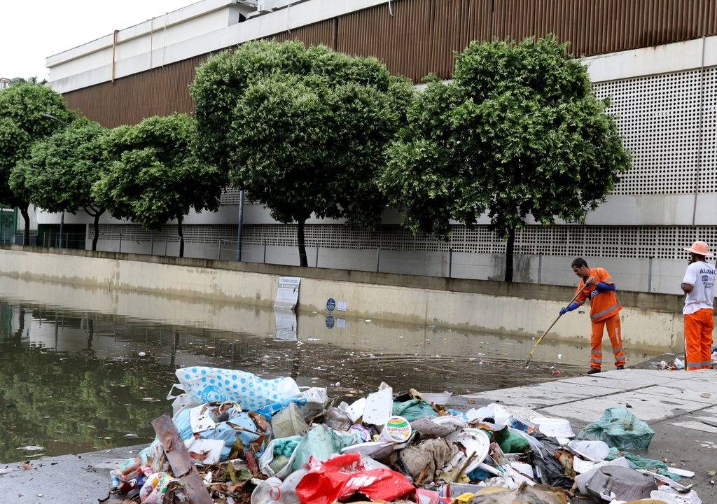 Foto mostra garis recolhendo lixo acumulado no Cais do Valongo, na Zona Portuária do Rio