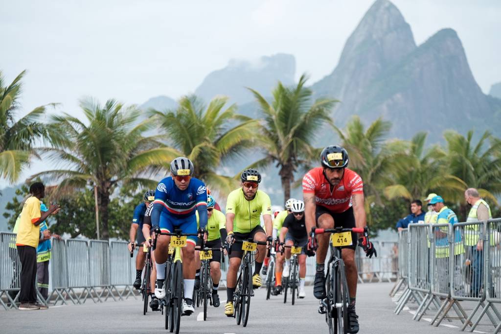Foto mostra ciclistas em competição na orla de Ipanema