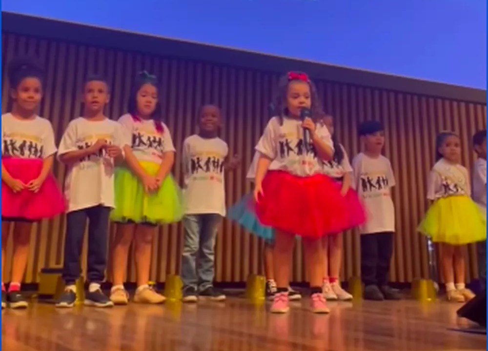 Foto mostra menininha cantando música sobre a baleia