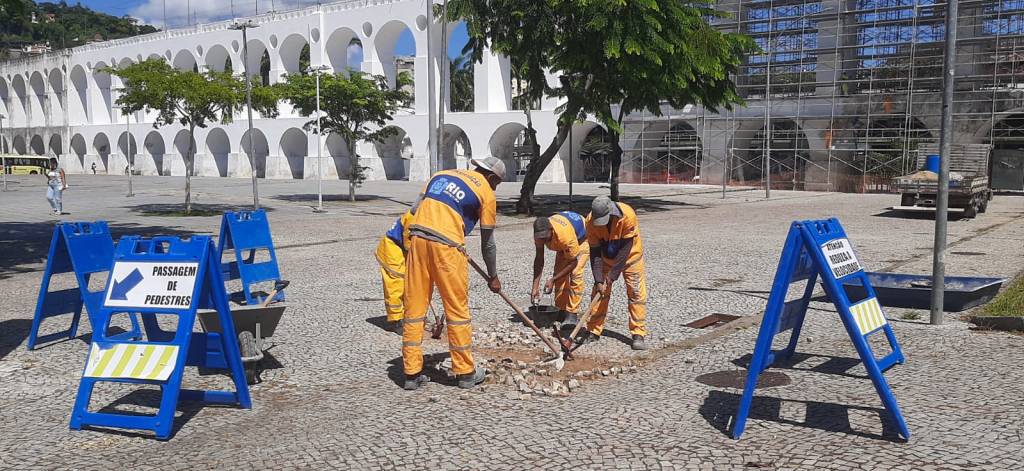 Foto mostra agentes da prefeitura mudando pedras da rua em frente aos Arcos da Lapa