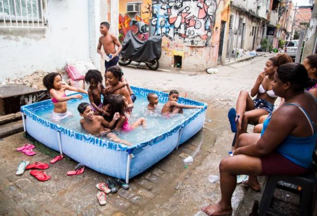 Elisângela Leite. Crianças se divertem na rua, em um beco na favela Nova Holanda, na Maré