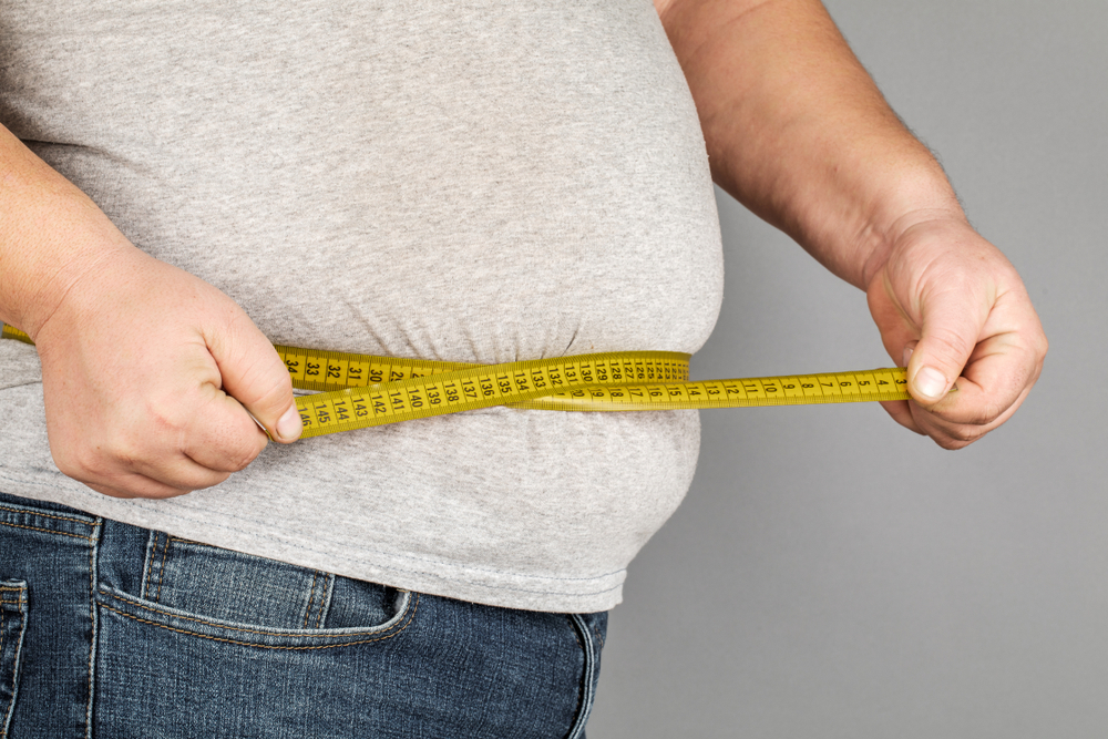 Fita métrica mede a circunferência da cintura de um obeso.