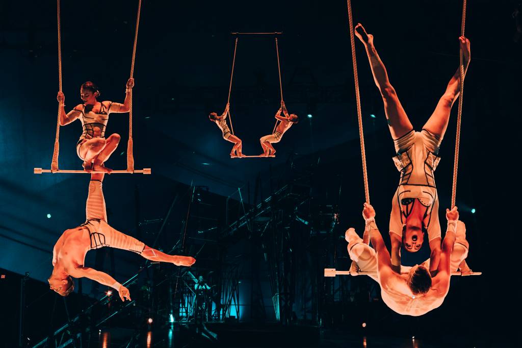 Três duplas de acrobatas no ar no espetáculo Bazzar, do Cirque du Soleil