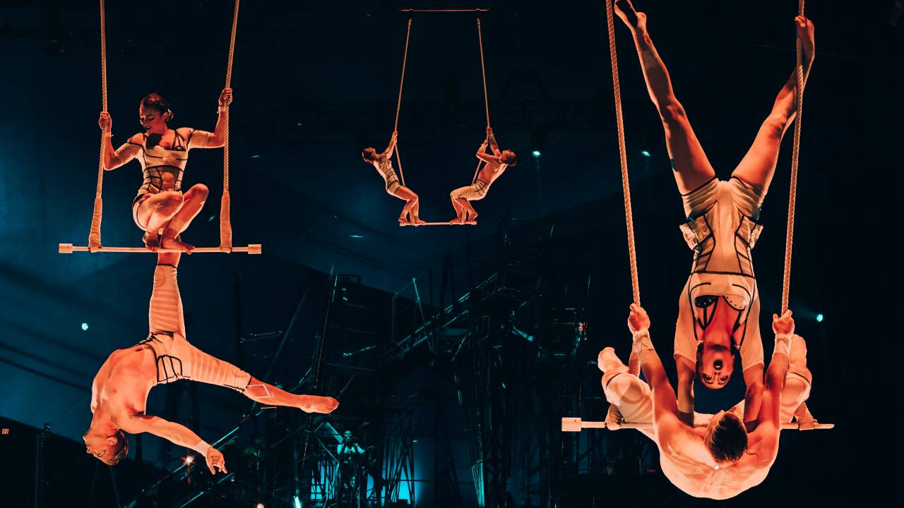 Três duplas de acrobatas no ar no espetáculo Bazzar, do Cirque du Soleil