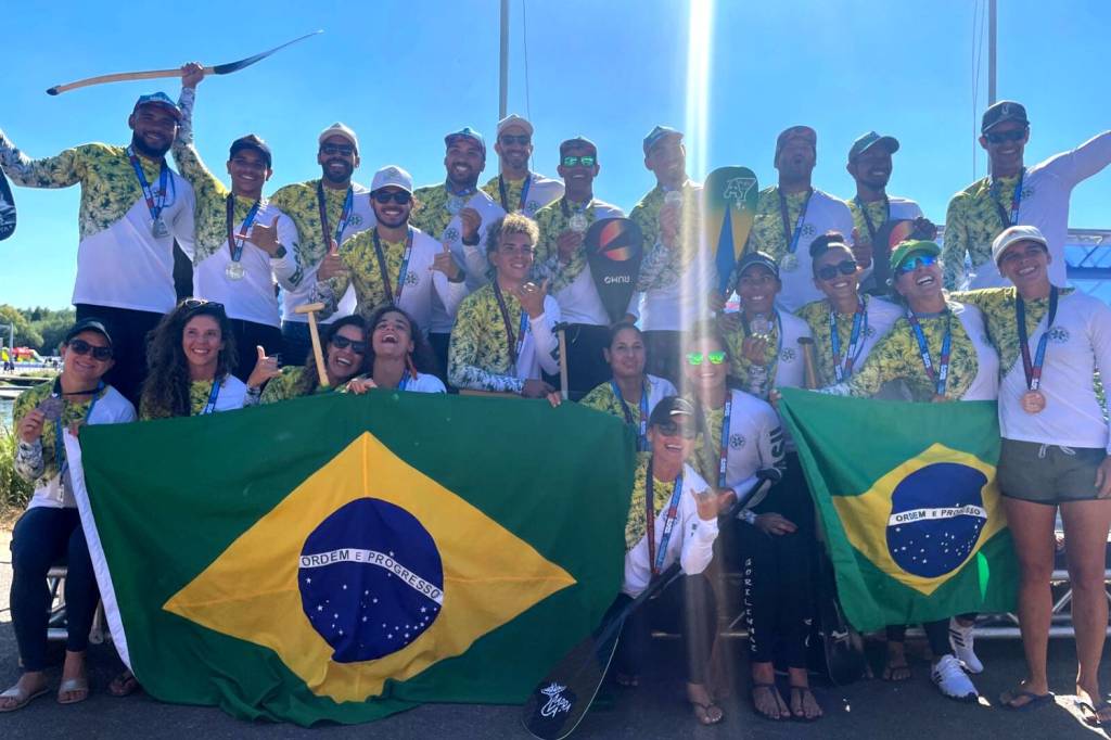 Foto mostra atletas brasileiros celebrando vitória na canoagem e segurando bandeiras do país
