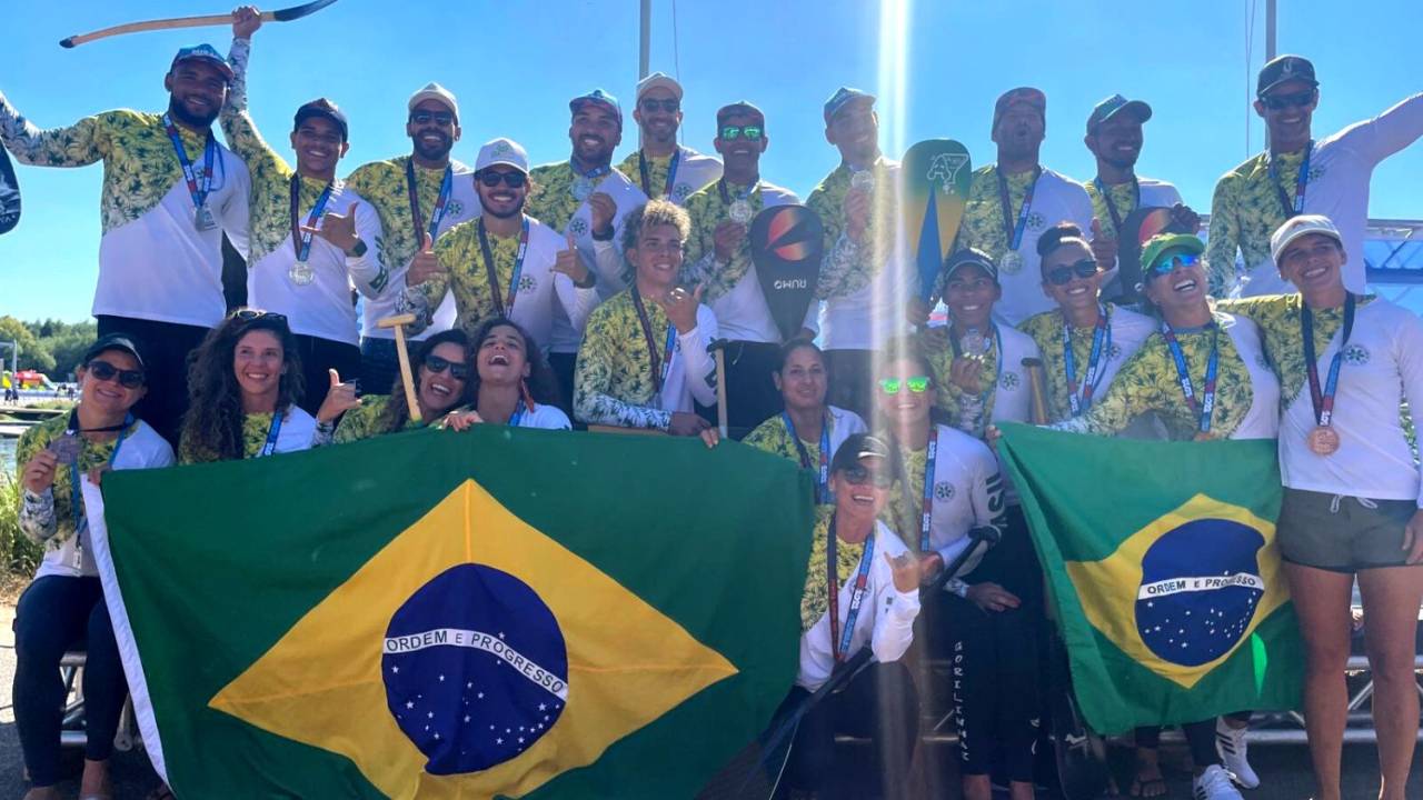 Foto mostra atletas brasileiros celebrando vitória na canoagem e segurando bandeiras do país