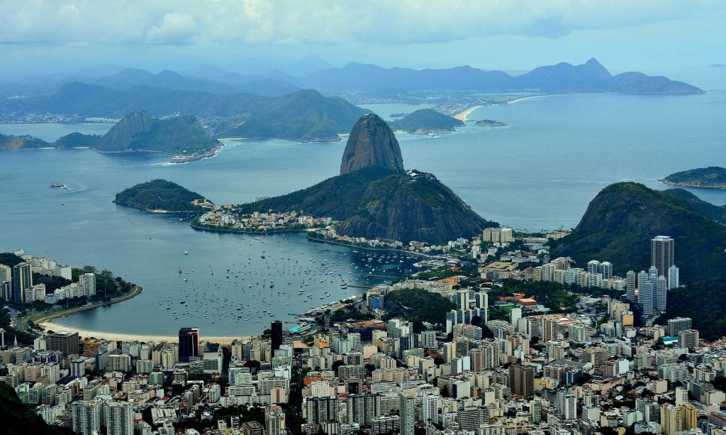Foto mostra RIo de Janeiro do alto com vista para o Pão de Açúcar e o bairro de Botafogo
