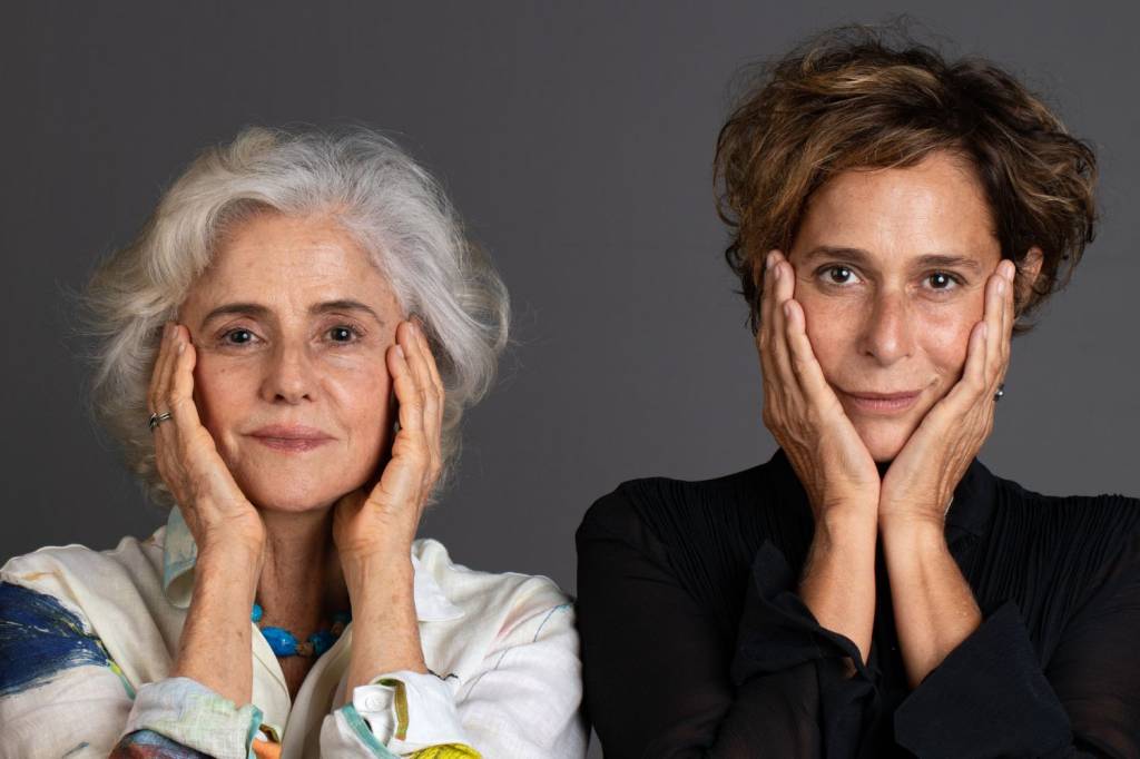 Foto mostra as atrizes Andréa Beltrão e Marieta Severo uma ao lado da outra com as mãos no rosto