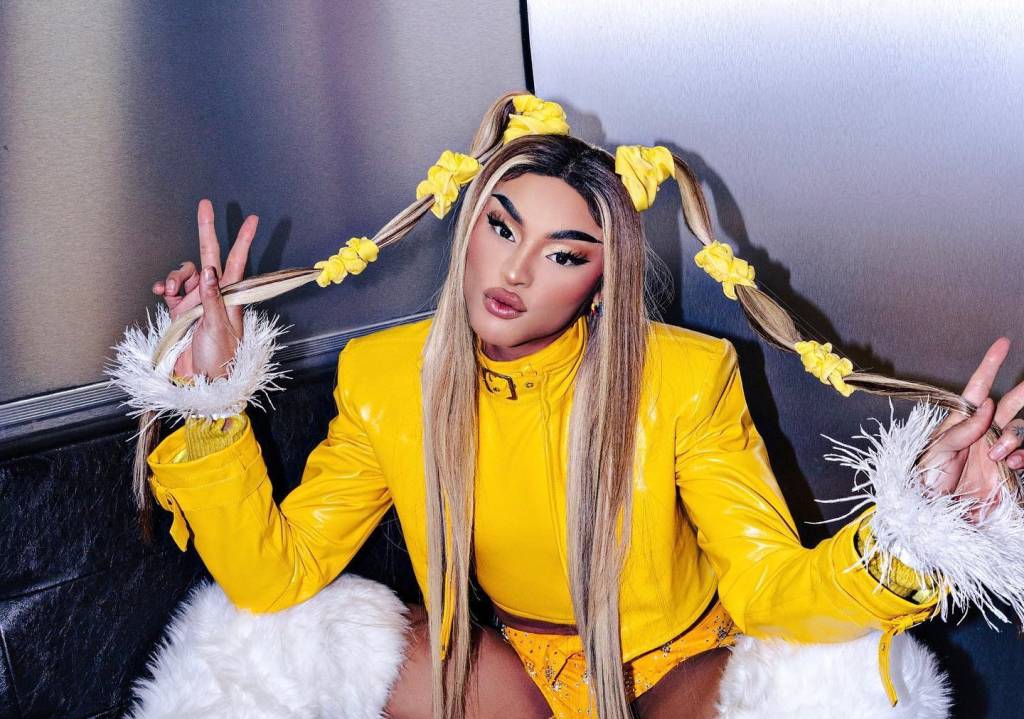 A cantora drag queen Pabllo vittar de jaqueta amarela, peruca louca e marias-chiquinhas.