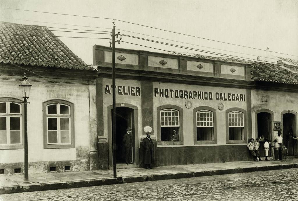 Foto em preto e branco da fachada de uma casa onde se lê Atelier Photographico Calegari