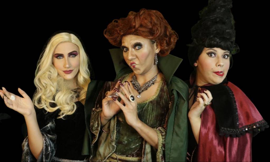 Foto mostra três mulheres caracterizadas como bruxas de peça infantil