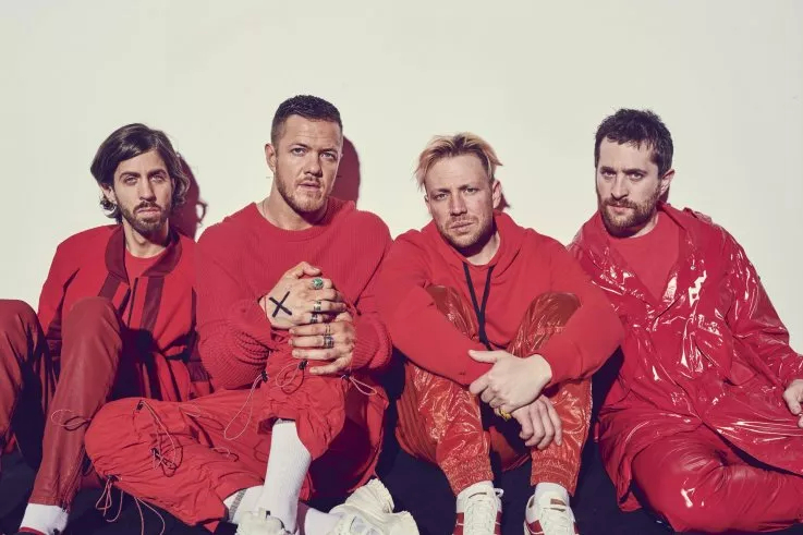 Os quatro integrantes do Imagine Dragons vestidos de blusa e calça vermelhas