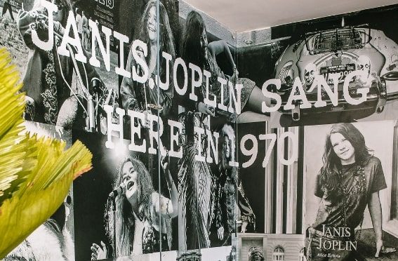 Paredes com fotos em preto e branco da cantora Janis Joplin.