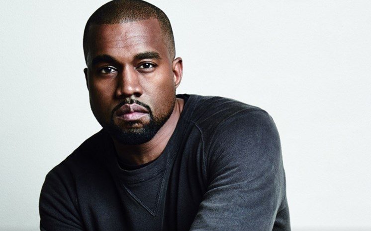 Kanye West usa blusa cinza de manga comprida.