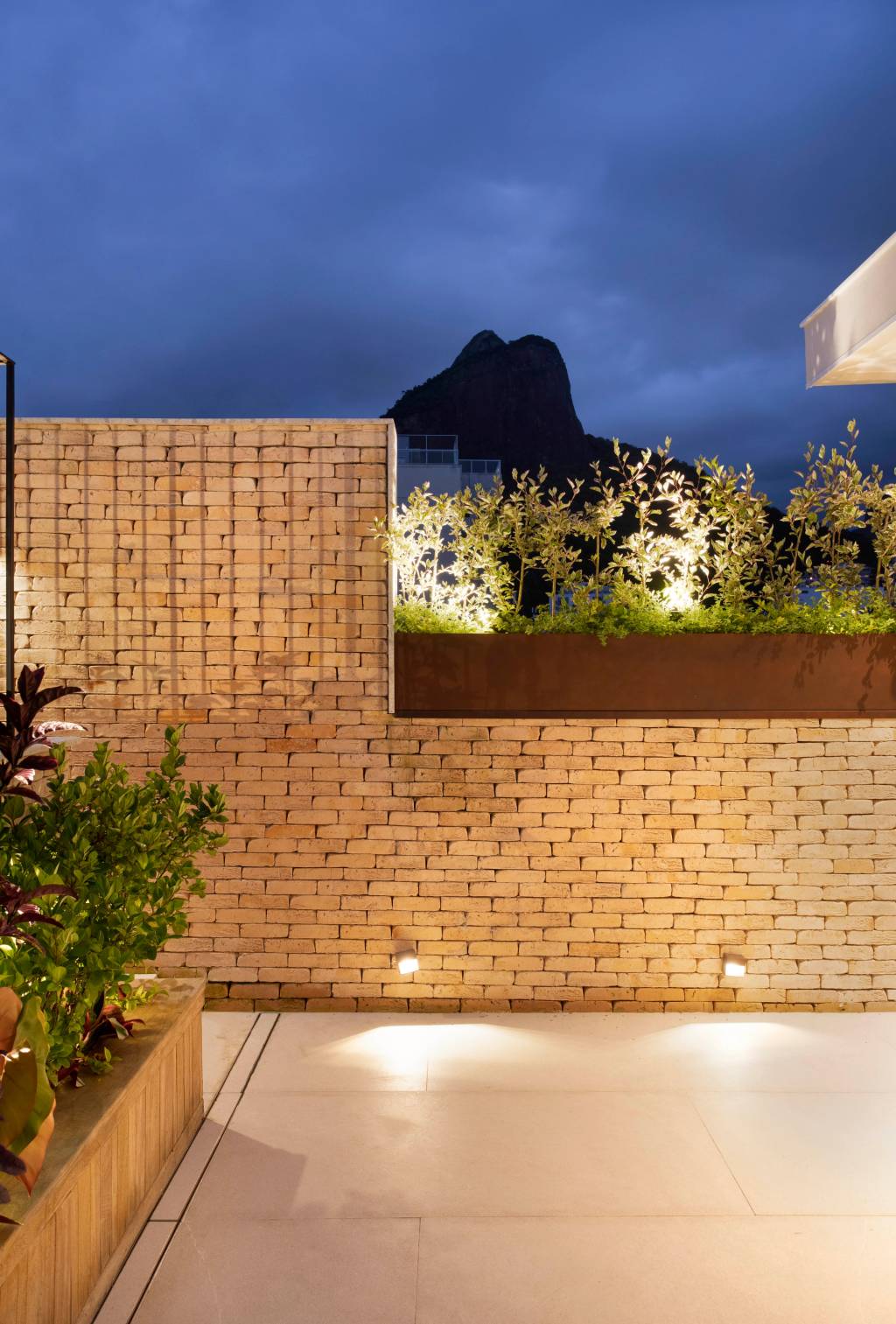 Varanda de cobertura vira jardim com folhagens coloridas e jardineiras