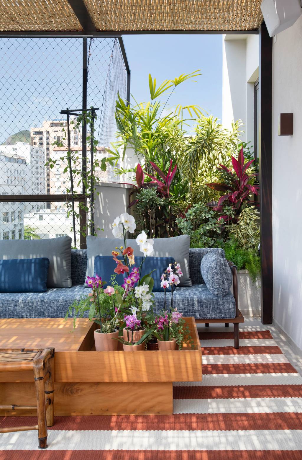 Varanda de cobertura vira jardim com folhagens coloridas e jardineiras