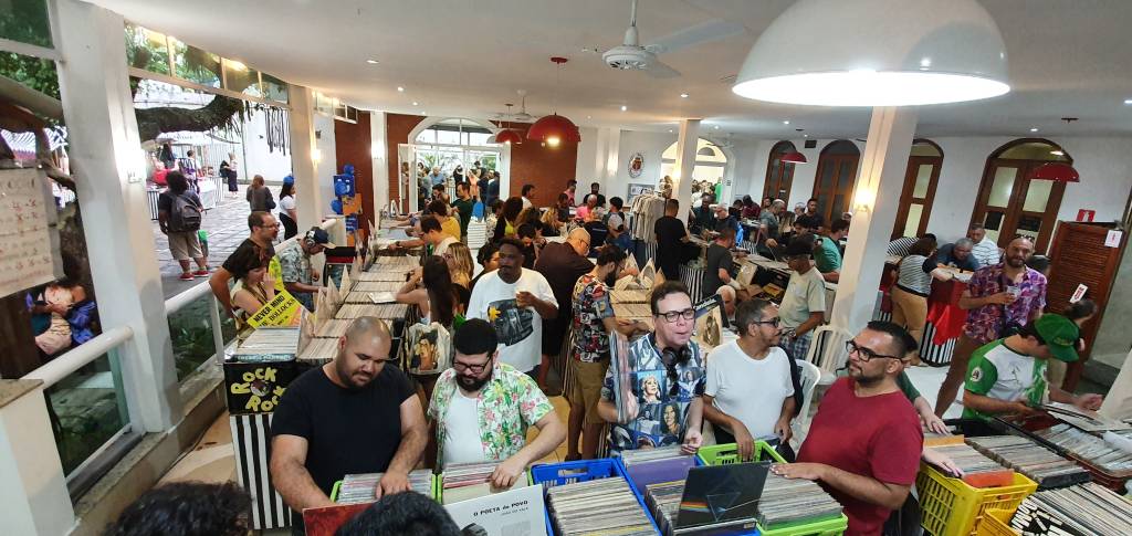 Foto mostra compradores olhando discos em feira