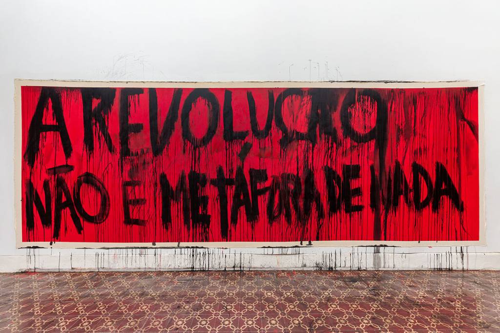 Foto mostra faixa-poema de Gustavo Spiridião escrita "A revolução não é metáfora de nada"