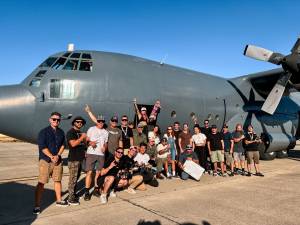 Equipe de filmagem em frente do avião de onde Letícia saltaria