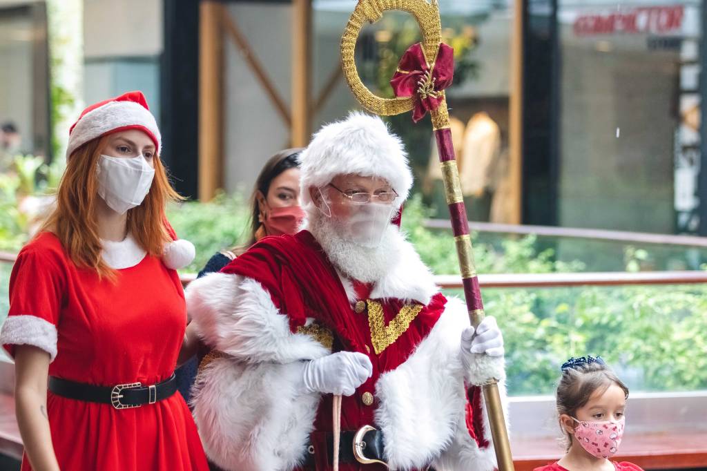 Foto mostra pessoa fantasiada de Papai Noel usando máscara de proteção contra a Covid