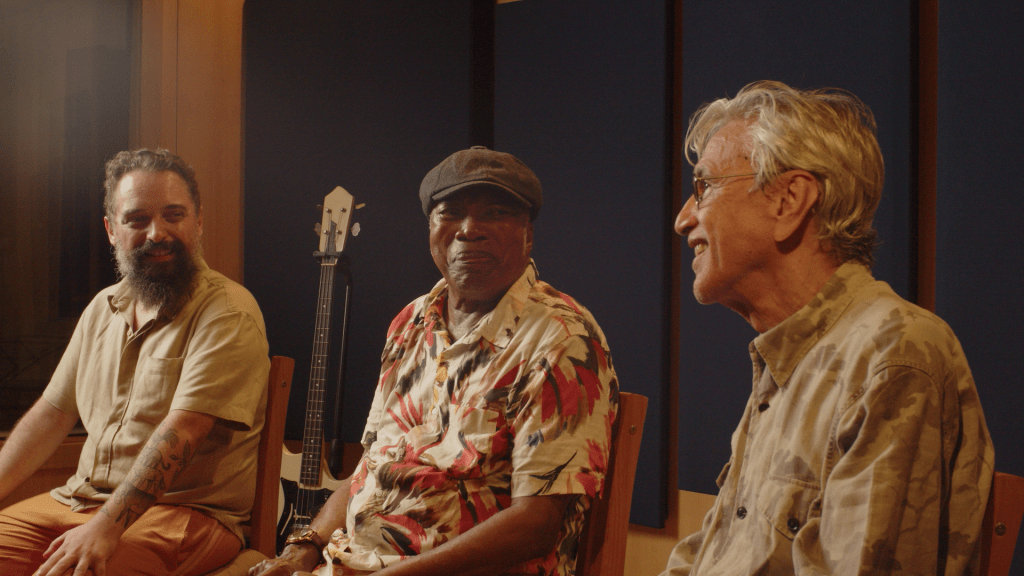 Foto mostra Milton Nascimento, Caetano Veloso e Chaps Melo gravando canção