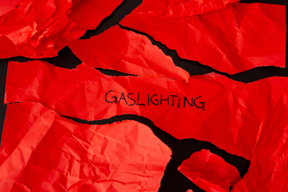 Um papel rasgado em vermelho com a palavra gaslight escrita nele.