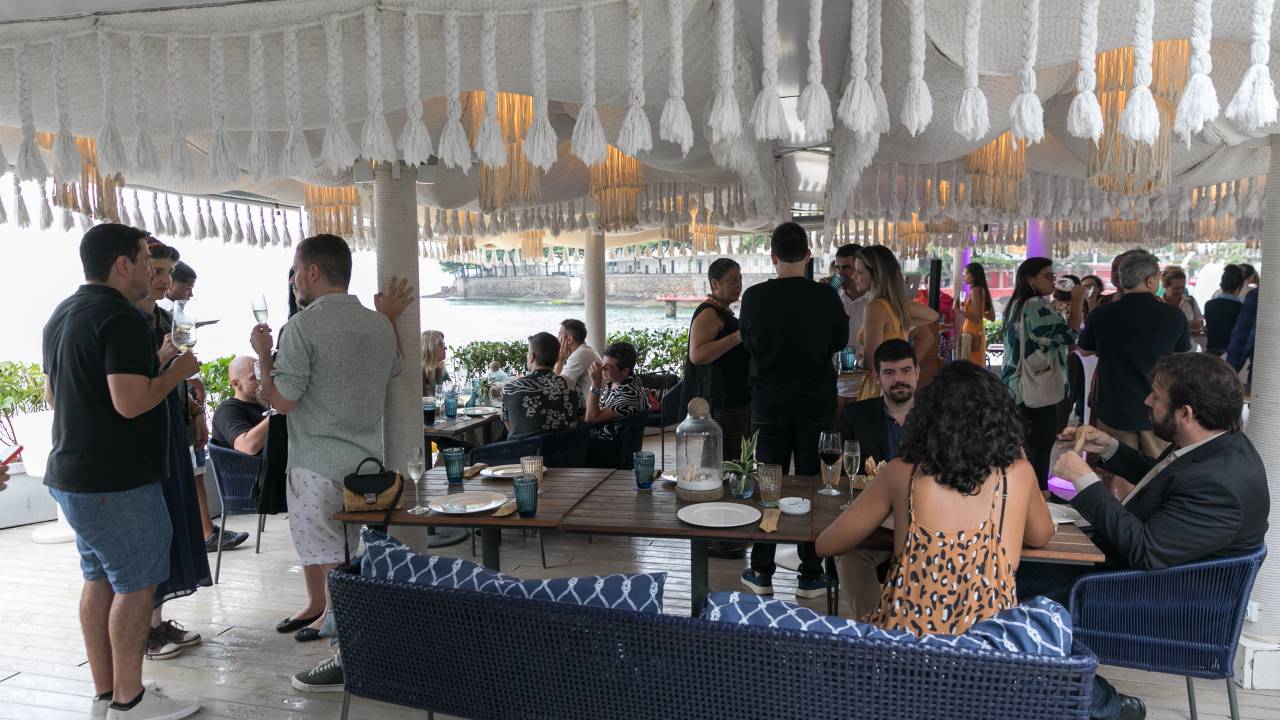 Foto mostra pessoas conversando em quiosque