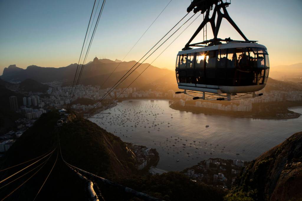 Foto mostra bondinho do Pão de Açúcar suspenso ao pôr do sol