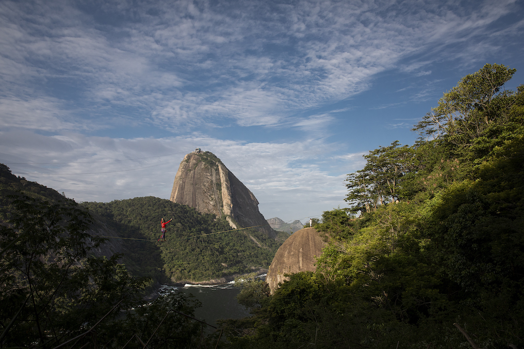 Foto mostra pessoa fazendo slackline com paisagem do Pão de Açúcar ao fundo