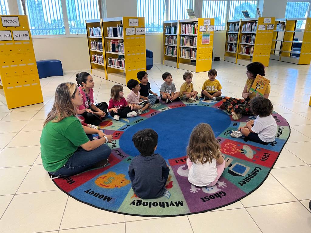 Foto mostra crianças participando de roda de leitura