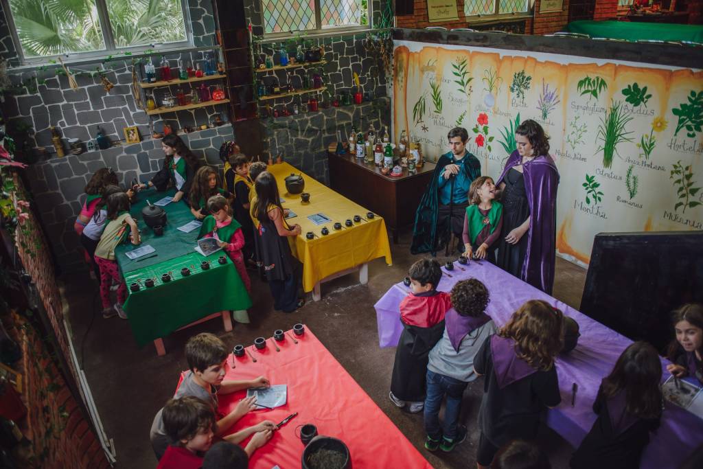 Foto mostra crianças tendo aula sobre magia em colônia de férias