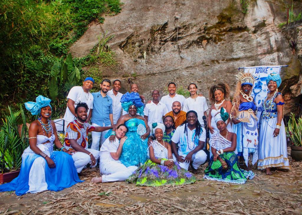 Homens e mulheres com roupas em tons de azul e branco, as cores de Iemanjá.