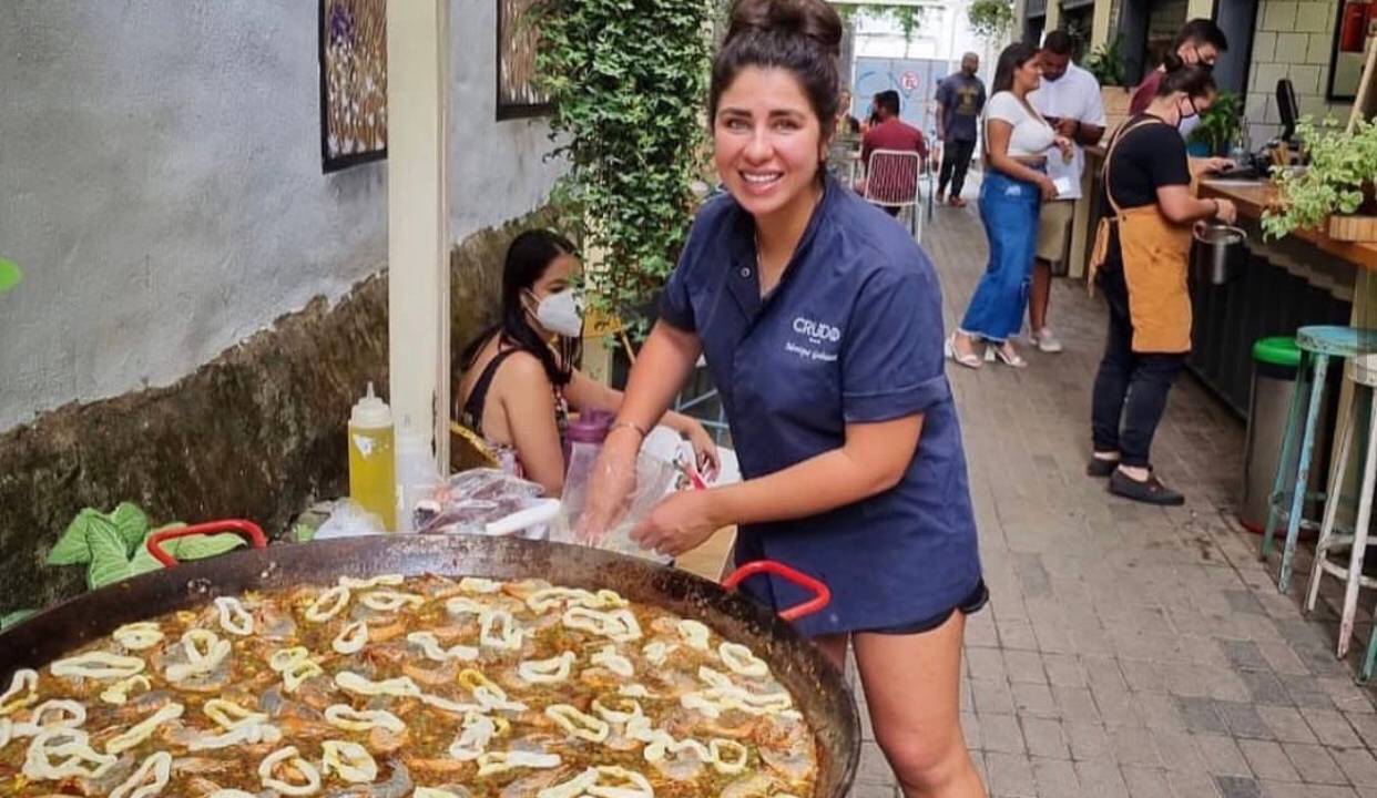 Monique Gabiatti: a chef em ação sobre uma de suas famosas paellas