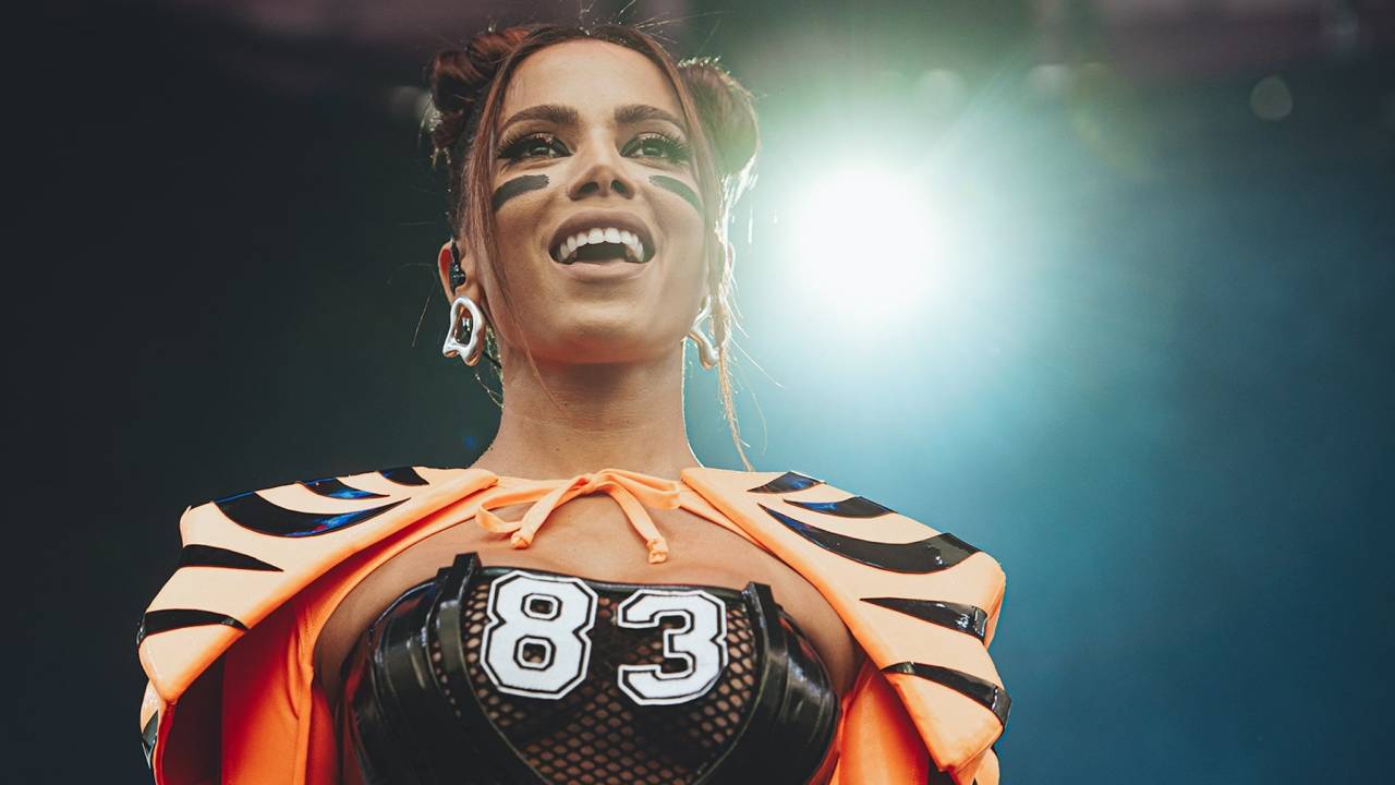 Anitta usa fantasia de jogador de futebol americano, com corpete preto com o número 83 e cobertura nos ombros em laranja e preto, imitando o pêlo de um tigre, em cores em referência ao time Cincinnati Bengals.