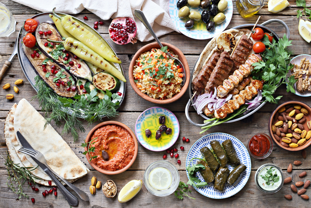 Mesa com diversos pratos e ingredientes do Mediterrâneo.