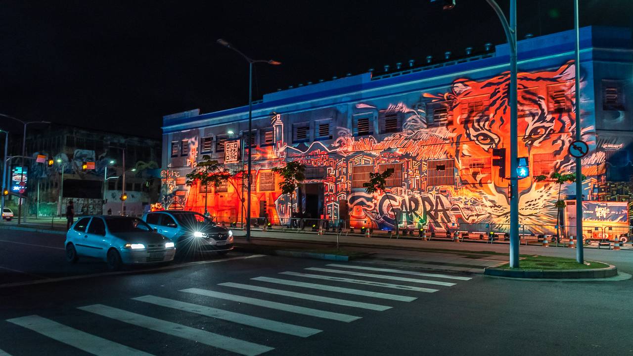 Foto mostra prédio com grafite pintado em vermelho